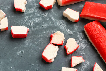 Pieces of tasty crab sticks on green background © Pixel-Shot