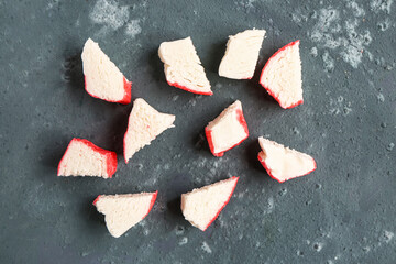 Pieces of tasty crab sticks on green background © Pixel-Shot