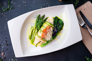 Fish fillet roll with zucchini, asparagus, spinach, red caviar and microgreens.