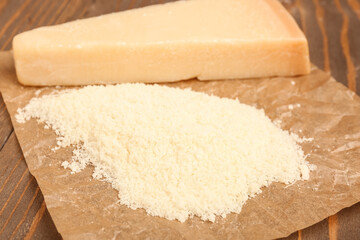 Tasty grated Parmesan cheese on wooden background, closeup