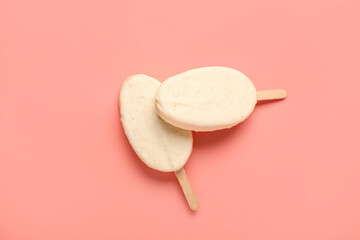 Delicious chocolate covered ice cream on stick against pink background