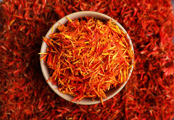 Bowl with pile of saffron as background, closeup