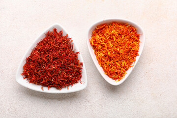 Bowls with pile of saffron on white background