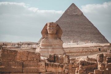 Majestic Pyramids of Egypt rise proudly against the vast desert landscape, a timeless testament to ancient civilization's architectural brilliance. Giza desert, Sphinx