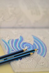 Fototapeta na wymiar Blue pencils and sea waves for coloring close up