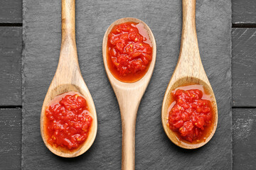 Spoons with tasty tomato sauce on table, closeup