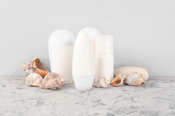 Different deodorants and sea shells on grunge table