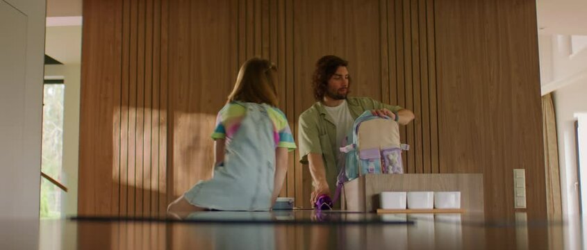 Father is late for work, helping his daughter to pack a backpack for school, girl mimics his emotions to a toy Generative AI