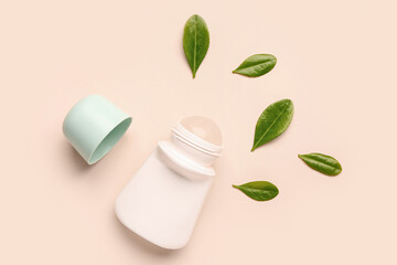Deodorant with leaves on beige background