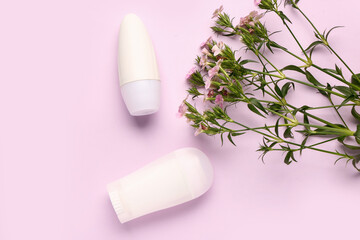 Deodorants with flowers on pink background