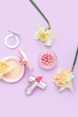 Fototapeta na wymiar Beautiful daffodils with different cosmetics on lilac background