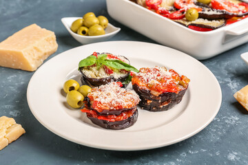 Plate with tasty baked Eggplant Parmesan on blue background