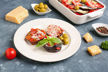 Plate with tasty baked Eggplant Parmesan on blue background