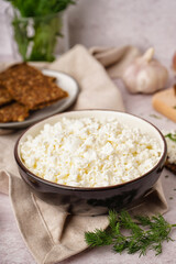 Bowl with tasty cottage cheese on light grunge background