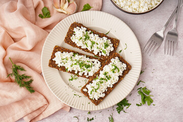 Plate with tasty cottage cheese and rye bread on light grunge background