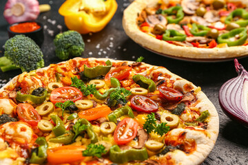 Vegetables pizzas with ingredients on dark background