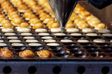 Making fresh poffertjes on market, Traditional Dutch batter treat, Resembling small fluffy pancakes...