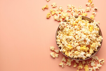 Bowl with crispy popcorn on beige background