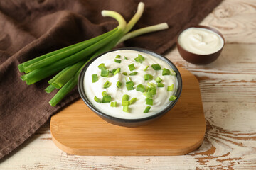 Composition with sour cream and sliced green onion on wooden table