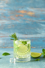 Glass of tasty mojito on blue background