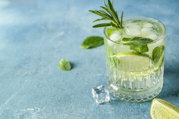 Glass of tasty mojito on blue background