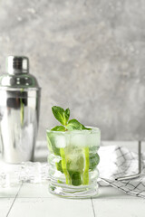 Glass of tasty mojito on table