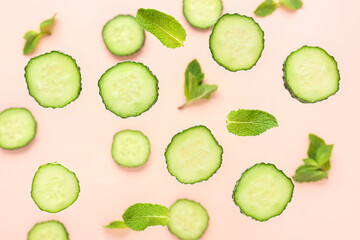 Slices of cucumber with mint on pink background
