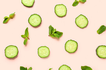 Slices of cucumber with mint on pink background