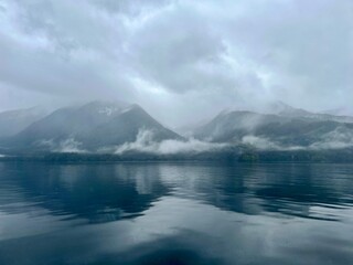 lake and mountains covered with mist in the morning