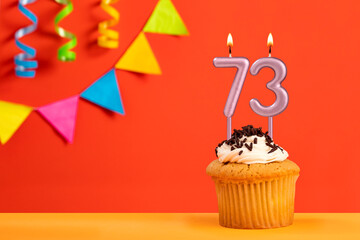 Birthday cake with number 73 candle - Sparkling orange background with bunting