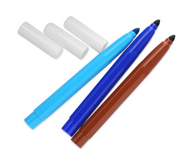 Different colorful markers and caps on white background, top view