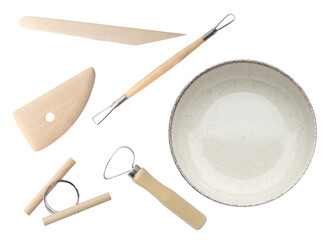 Set of pottery tools and ceramic bowl on white background