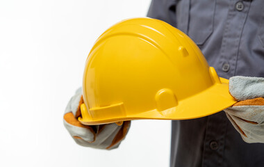 Man in gloves holding yellow helmet on white background. Close-up