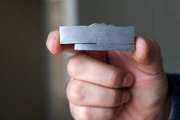 Welding inspector is holding a welded macro sample. Macro test or macro examination is performed on...