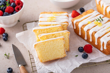 Classic vanilla pound cake with powdered sugar glaze sliced on parchment