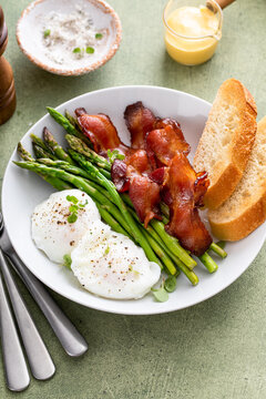 Healthy breakfast with poached eggs, bacon and asparagus