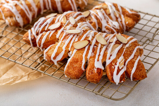 Bear claw pastry on a cooling rack with glaze and almonds