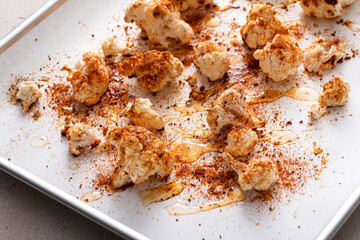 Cauliflower with olive oil and spices ready to be roasted