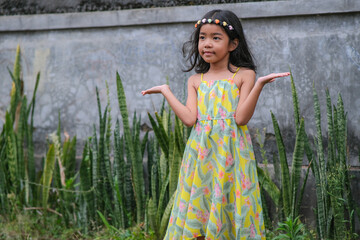 Obraz premium Little Asian girl wearing colourful hair band posing to have her photo taken