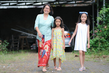 Fototapeta na wymiar An Asian mother walking hand in hand with her two beautiful daughters