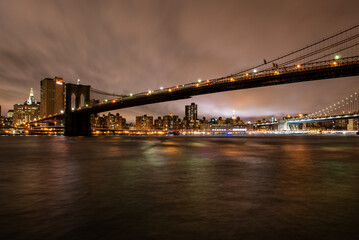 Fototapeta na wymiar View of Lower Manhattan, the World Trade One building and the surrounding Brooklyn Bridge, as seen from Brooklyn, near the D.U.M.B.O.