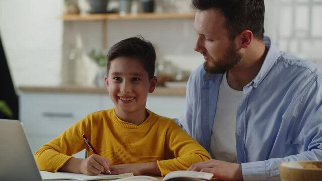 Smiling boy doing homework with his father. A man sits at a table next to his son and helps him do his homework. Generative AI