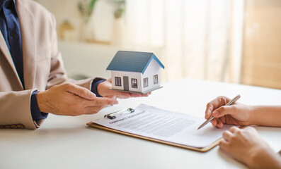 Fototapeta premium Real estate services for buying home holds house model and calculating table payment to customer.