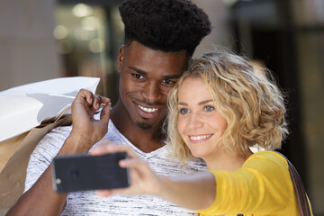 attractive young couple with shopping bags taking a selfie