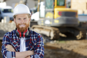 male builder at outdoor site wearing protective equipment