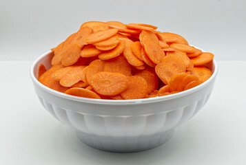 Carrot slice in a bowl isolated on white background