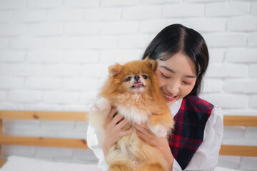 Beautiful asian woman holding her playful furry canine friend.