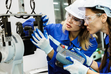 female automation machine engineer student study and inspection control robot arm machine in university or factory workshop. ai robot technology new innovation trend of manufacturing in industry 5.0