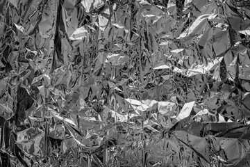 Shiny silver foil texture for background. Black and white photo.