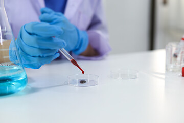Scientist holding Coronavirus covid-19 infected blood sample tube DNA testing of the blood in the laboratory with blood sample collection tubes and syringe Coronavirus Covid-19 vaccine research.